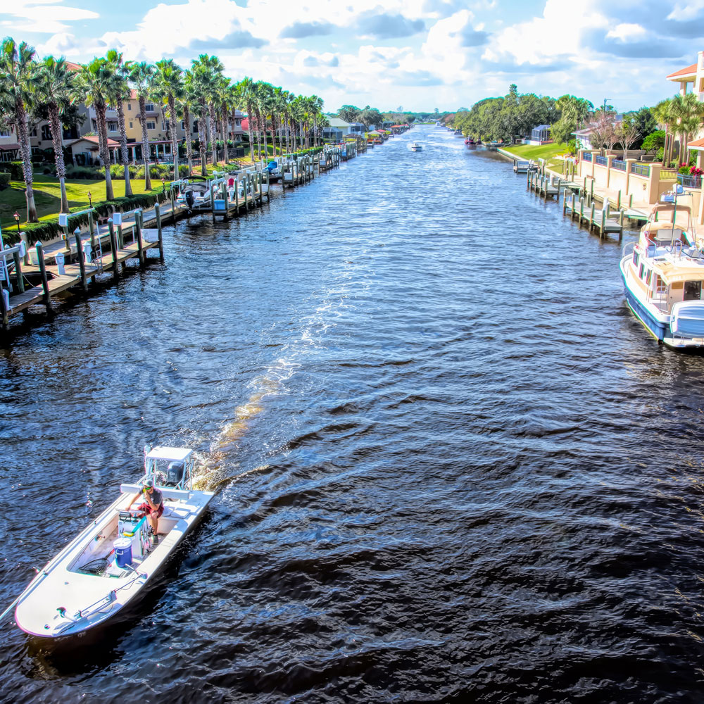 A motorized boat moving through the waters of a canal in Palm Coast.